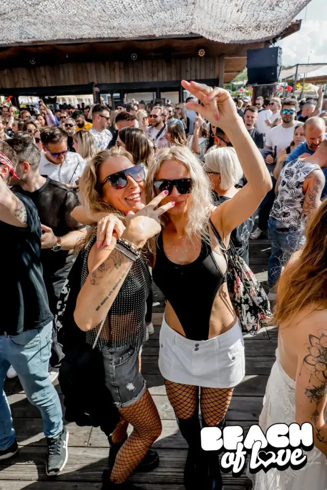 Zwei Besucherinnen tanzen mit Sonnenbrille in der Menge