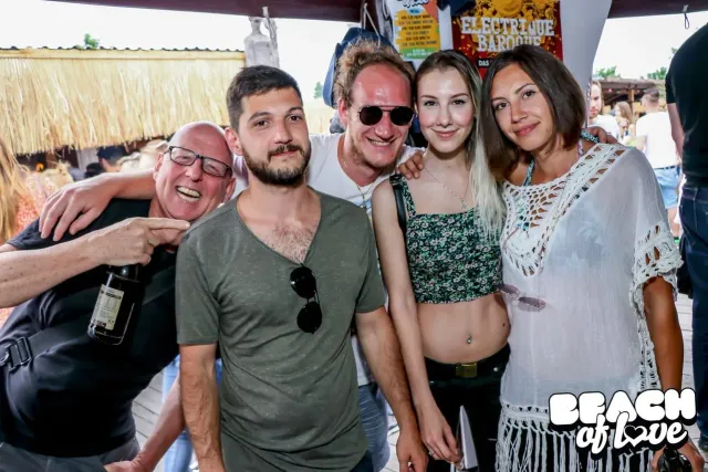Gruppe von Freunden posiert gut gelaunt am Strand
